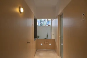 A minimalist hallway with wooden walls and white doors.