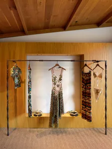 A wooden wall display showcasing various garments and footwear.