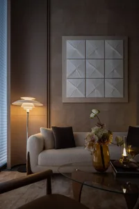 Modern living room with fabric couch, wall art, and floor lamp.