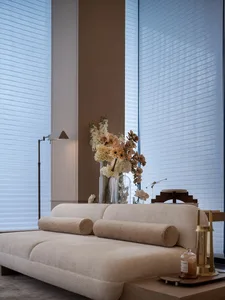 Modern minimalist living room featuring a beige sofa with textured fabric, a floor lamp with a rectangular shade, and a vase 