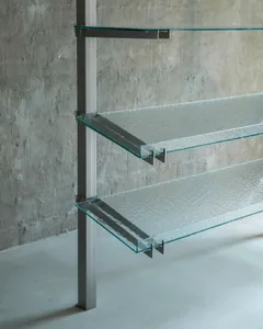 A minimalist glass shelf rack mounted on a concrete wall, featuring transparent glass shelves.