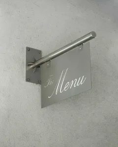 A metal menu sign hanging on a wall.