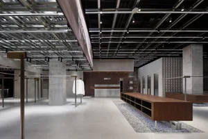 A minimalist retail space featuring concrete, wood, and glass materials.