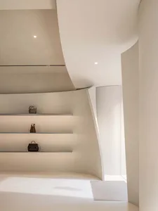 Modern architectural interior with minimalist design, featuring sleek metal shelves with bags on them.