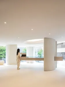 A modern interior space with concrete walls and a glass desk.