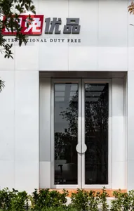 A glass door with a white panel on the international duty free storefront.