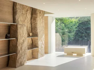 Minimalist retail store featuring stone walls and a large glass window.