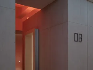 A modern interior design featuring a concrete wall with minimalist design elements and subtle lighting.