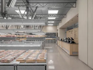 Modern retail store interior with metal shelves, glass display cases, and wooden checkout counters.