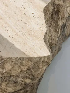 A close-up view of a stone architectural detail showing its textured surface and edges.