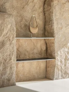 Industrial style stone display shelf with a beige handbag on top.