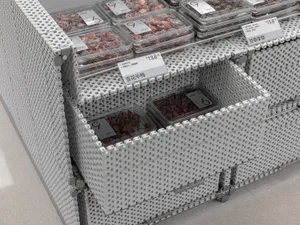 A display case showcasing dried fruits in plastic containers with price tags.