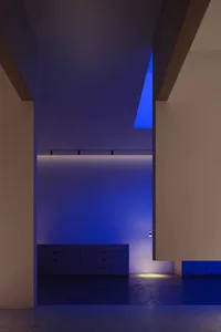 Concrete bedroom with blue lighting and modern furniture