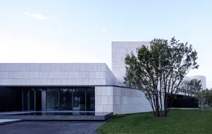 Modern architectural building with concrete exterior and large glass windows.