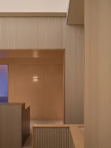 Modern interior design featuring a corridor with metal-cladding walls and illuminated lighting.
