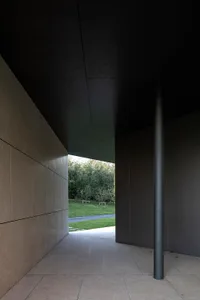 Modern entryway featuring sleek concrete and metallic elements.