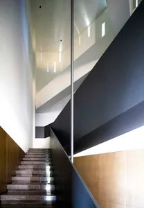 A modern staircase with glass and concrete materials.