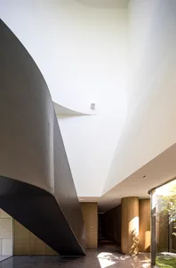 A modern interior space featuring white walls, curved architectural elements, and natural light.