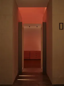 A minimalist interior with a concrete floor and warm lighting.