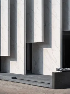 Modern building exterior with marble façade and concrete details.