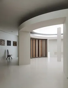 Minimalist white interior with wood, concrete and plaster elements.