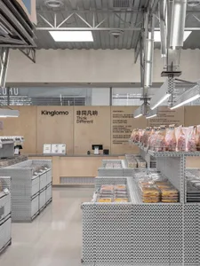 A modern grocery store with metallic shelving, well-lit ceiling lights, and a checkout counter.