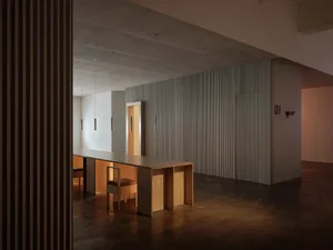 Minimalist concrete living room with minimalist furniture and warm lighting