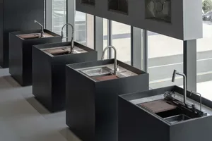 Four minimalist kitchen setups featuring black metal, granite, and wood finishes.