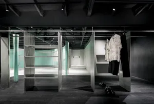 Modern minimalist clothing store interior with metal racks and glass dividers