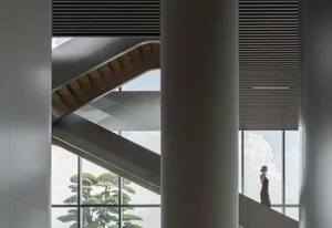 A modern interior design open space with a curved staircase and natural light.