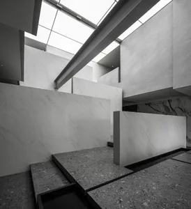 An interior space featuring white marble and concrete elements