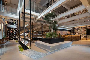 Modern bookstore with industrial design elements and a central plant.