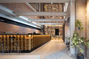Industrial-themed coffee shop featuring exposed brick, concrete, and light wood elements.