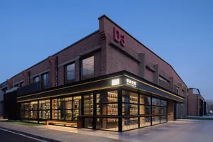 A modern bookstore interior with brick walls, concrete floors, and abundant glass windows.