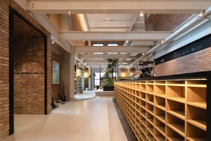 Modern coffee shop featuring brick, concrete, and timber materials.