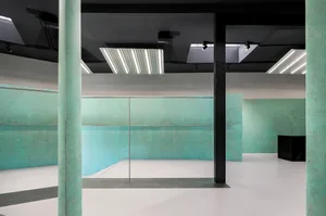 A minimalist modern interior featuring concrete flooring and walls.