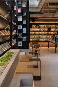 現代圖書館室內，擁有磚牆與混凝土牆面、玻璃與金屬書架，以及座位區。