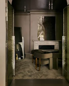 A modern residential lounge with metallic texture, featuring a fireplace and seating area.