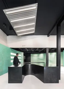 A modern retail space featuring a sleek, black desk and green walls.