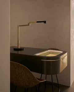 A modern desk workspace with a metallic desk lamp and a sleek, metallic desk.