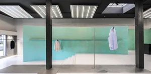 Modern retail shop interior with concrete walls, minimalist design, and natural light.