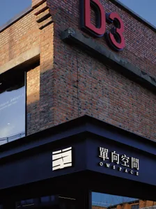 A modern storefront with a brick facade and large glass windows.