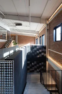 Industrial-style stairs with metal railings and a metal panel wall.