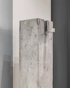 Modern living room with minimalist decor, featuring a concrete column as a central architectural element.