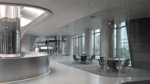 A modern conference room featuring glass walls and concrete columns.