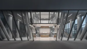 A modern office lobby featuring sleek metal, glass, and concrete elements