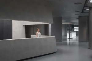 Modern minimalist office space with concrete finishes and sleek design.