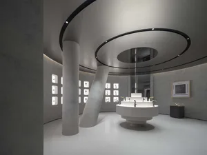 A minimalist showroom featuring concrete, glass, and steel materials.