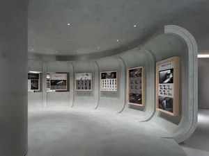An exhibition space showcasing a variety of products mounted on concrete walls.