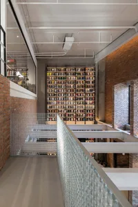An industrial-style library featuring brick walls, concrete flooring, and glass railings.